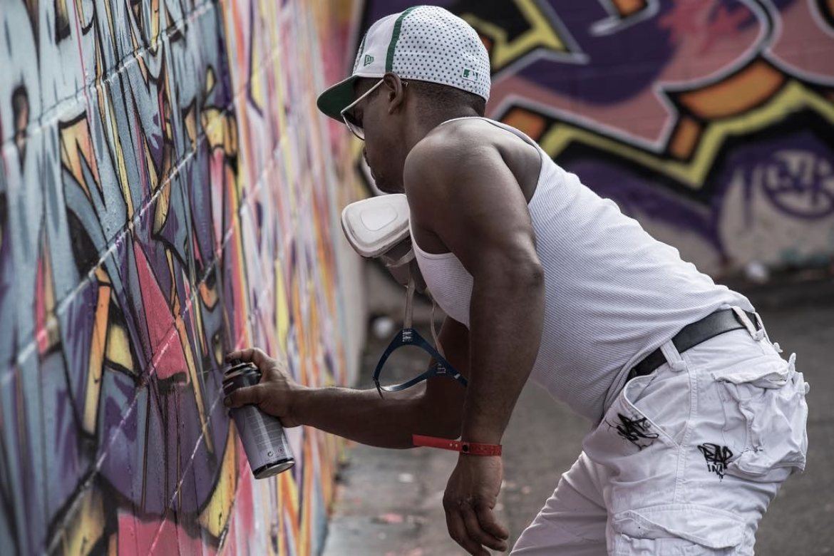 Graffeur masqué devant son mur